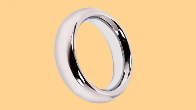 A single stainless steel cock ring from T-Language in front of an orange background.