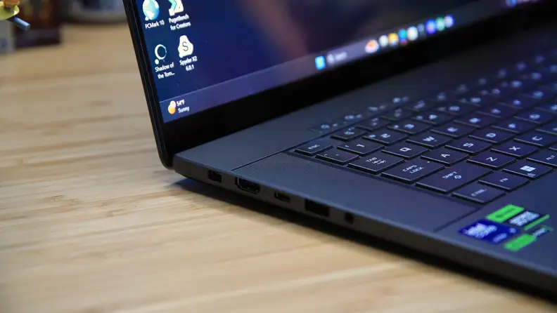 A close-up on the side of the Asus ROG Zephyrus G16 laptop, that's sitting on a desktop.