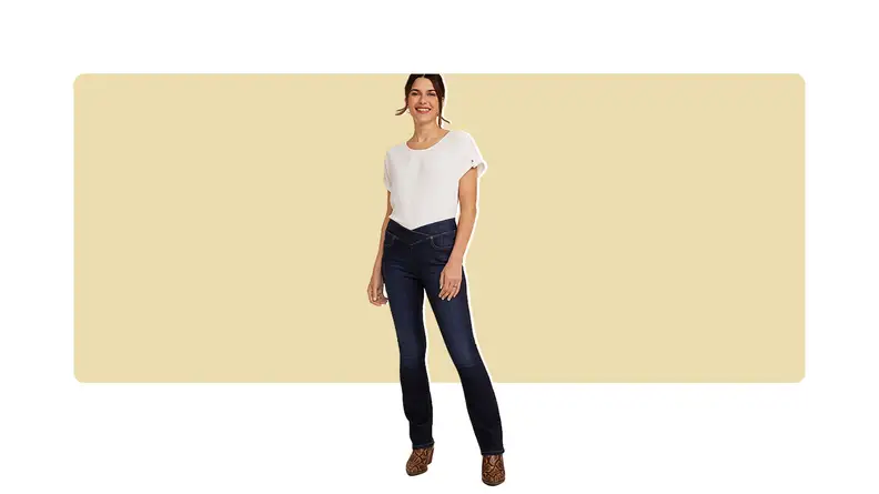 A model wearing dark bootcut jeans with a crisscrossed waistband and a white T-shirt.