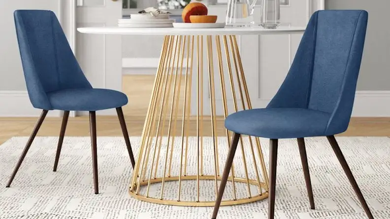 Two blue chairs and a gold and white table.