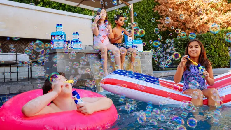 Kids in a pool blowing bubbles