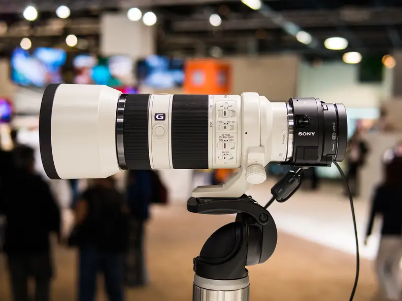 You can put some serious glass on the QX1, but you'd better pack a tripod.
