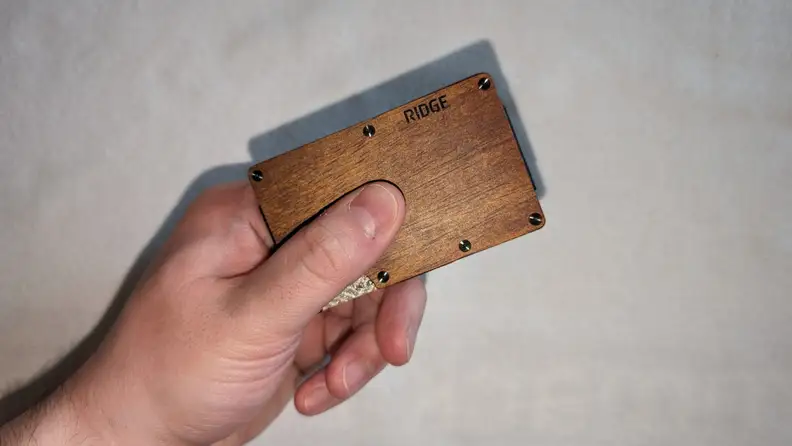 The Ridge Mopane Wood wallet being held in front of a white background.