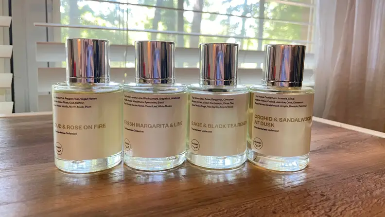 Four bottles of perfume lined up on a table.