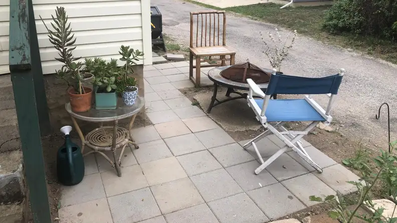 A small patio with folding chair and succulents.