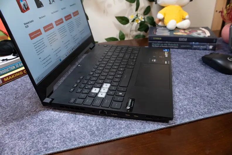 A side view of a black laptop, open and powered on