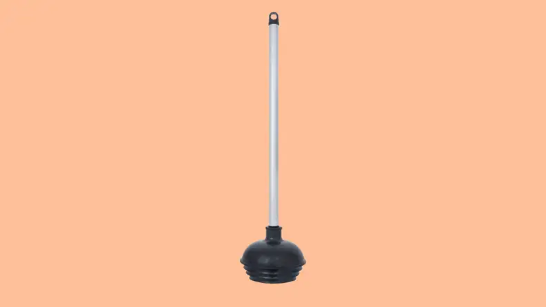 A toilet plunger against a peach background.