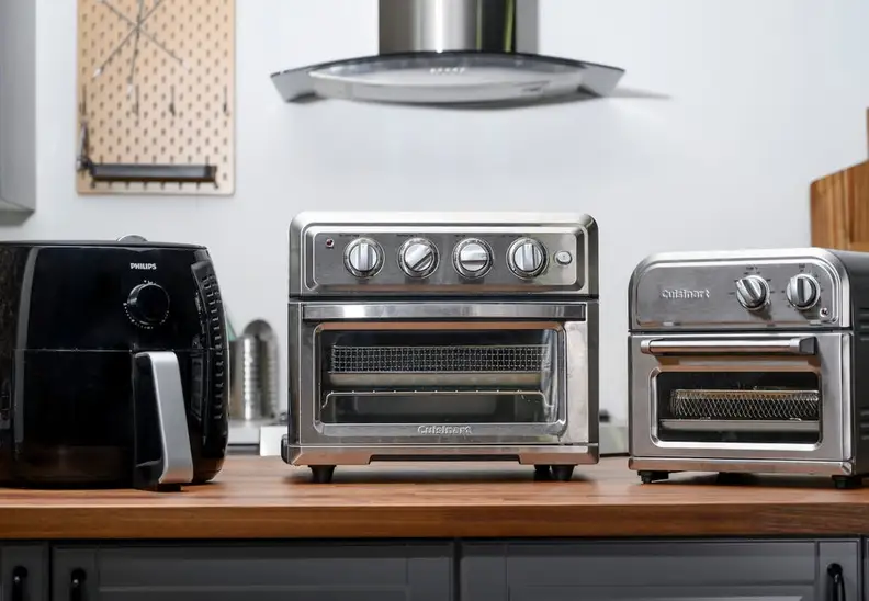 Three air fryers on a kitchen countertop