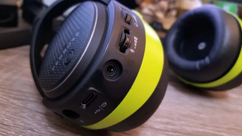Close-up: On the bottom of a gaming headset, we see the power button, three ports, and volume controls for the microphone and earpieces.