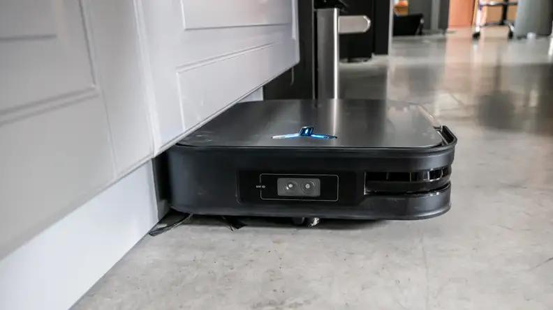 The Ecovacs Deebot X2 Omni cleaning under a toe kick