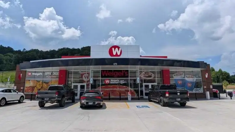Exterior of a Weigel's convenience store with cars parked out front