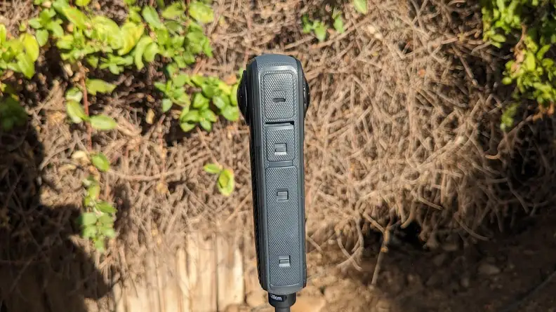 A side view of the Insta360 X4 Action Camera outdoors.