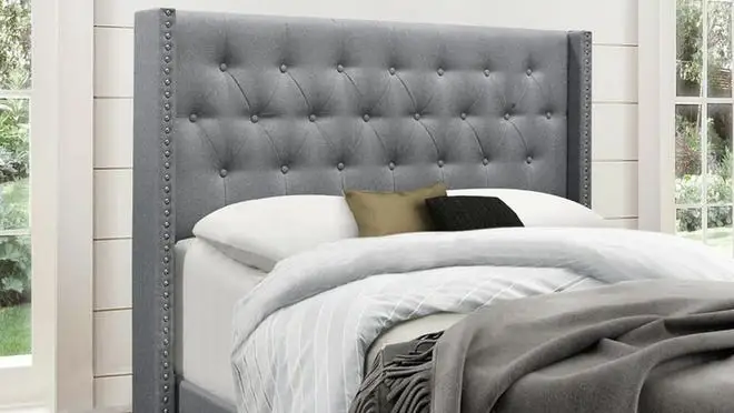 Gray tufted bed in bedroom