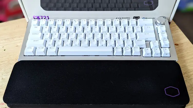 A white keyboard above a black wrist rest
