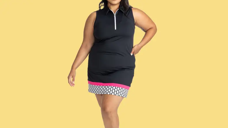 A model wearing a black thigh-length dress with pink and printed details along the bottom hem.
