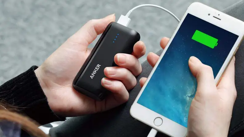 Person holds a phone and portable charger in hands