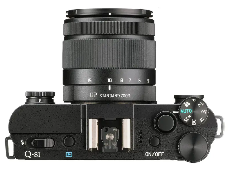 The Pentax Q-S1 retains the pop-out flash, hot shoe, and top plate control cluster from the Q7.