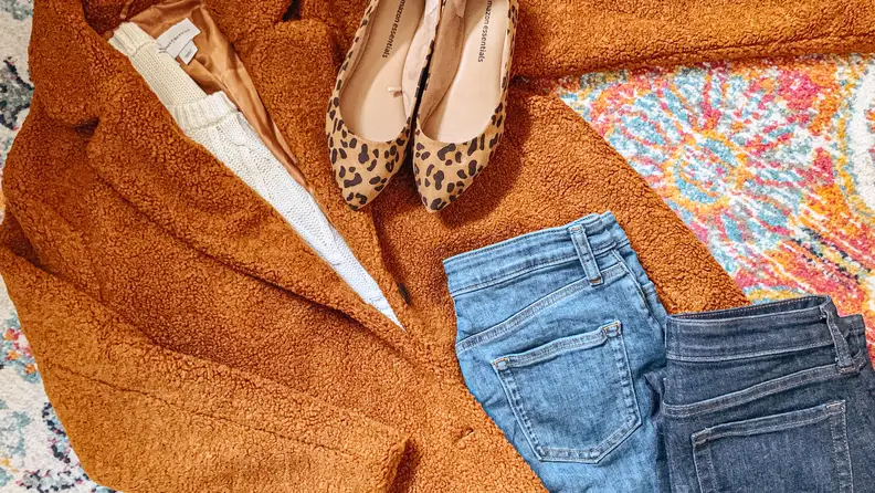 A few items of clothing placed on top of one another on a colorful rug.