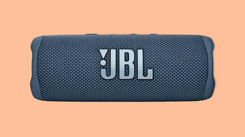 A navy blue JBL Flip 6 portable bluetooth speaker on an orange background.