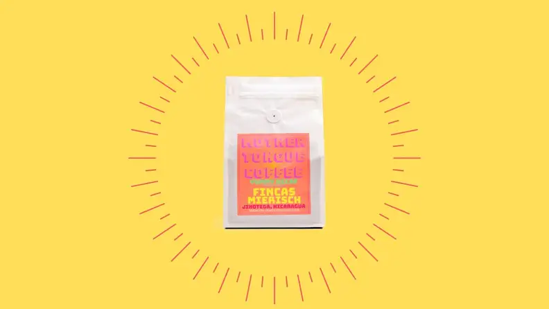 A bag of decaf coffee against a bright yellow background.