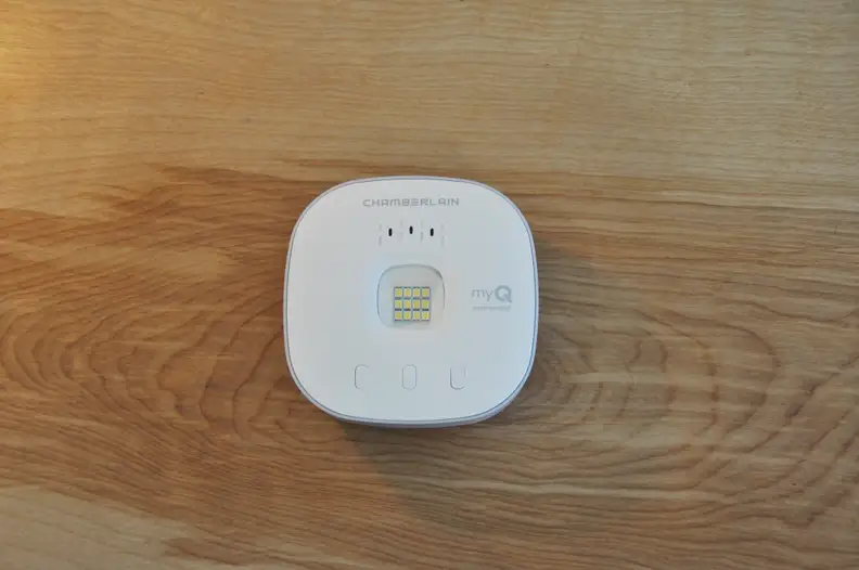 an uninstalled smart garage door opener sits on a table