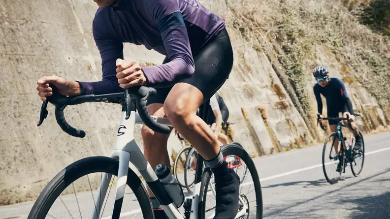 A man rides a bike on a paved road