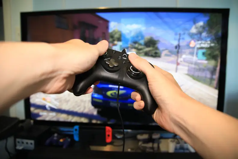 A pair of hands holding the controller to play video games.