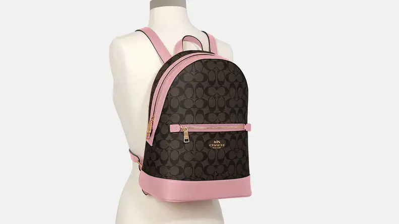 A brown and pink Coach backpack on a mannequin.