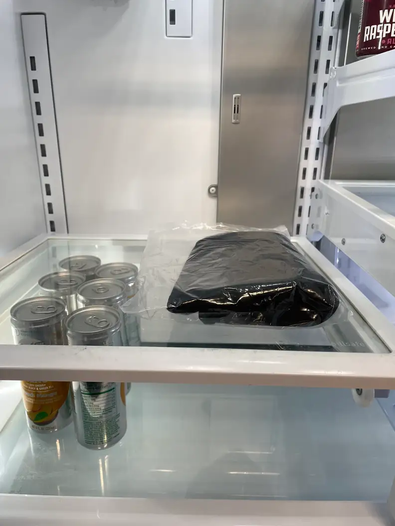 The AllSett Health Migraine Relief Cap in a plastic bag, inside a refrigerator.