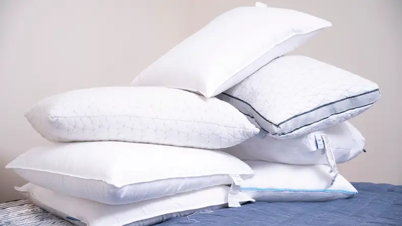 a pile of pillows on a bed