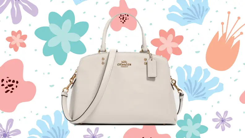 A white Coach shoulder bag against a floral background.