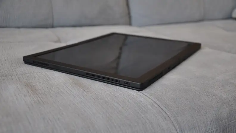 The all-black fold is fully extended, sitting on a grey couch like a tablet.