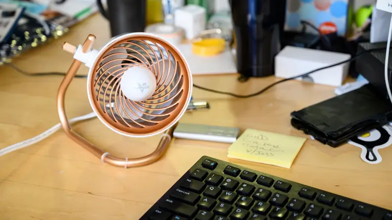 The Vornado Pivot desktop fan sitting on an office desk.