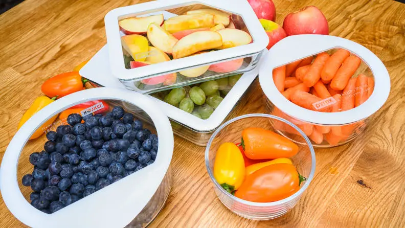 Pyrex containers filled with fruits and vegetables.