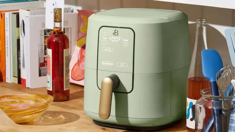 Actress Drew Barrymore's mint green air fryer sits on a kitchen counter.