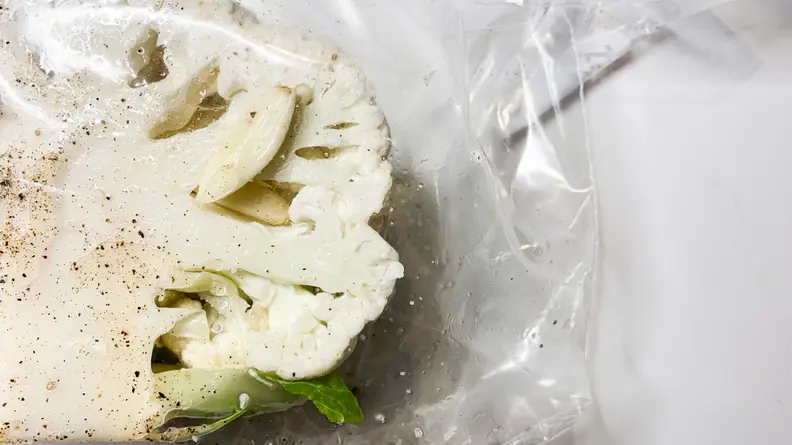 An illustration of half of a head of cauliflower packaged in a sous vide bag pre-cooking.