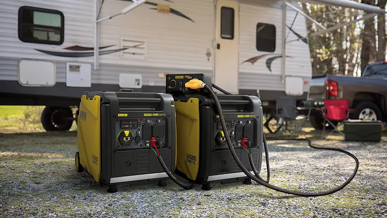 An inverter generator sitting on the ground outside an RV.
