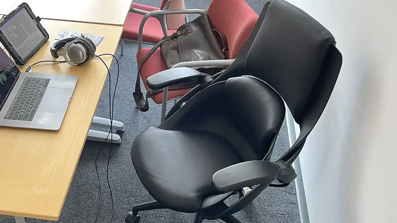 A close-up of the cup-like seat of the chair, which does not naturally line up with the upper back support.