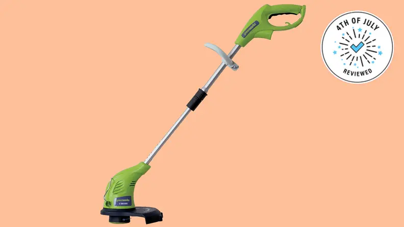 The Greenworks electric trimmer, floating in a peach void.