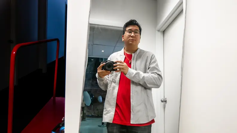 Man in long-sleeve shirt in front of mirror