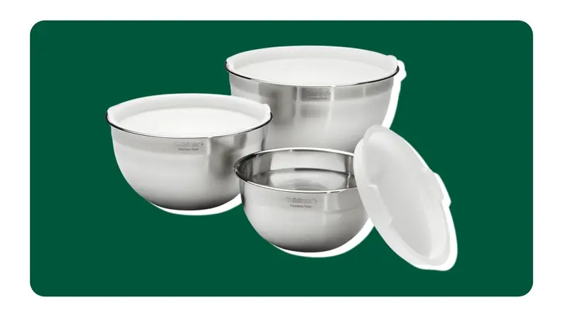 Three stainless steel mixing bowls on a green background