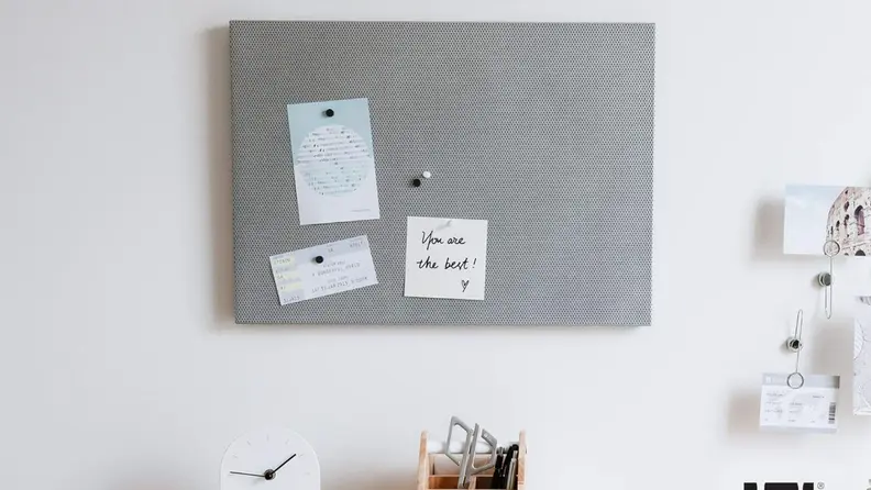 Magnetic board on a wall with paper attached