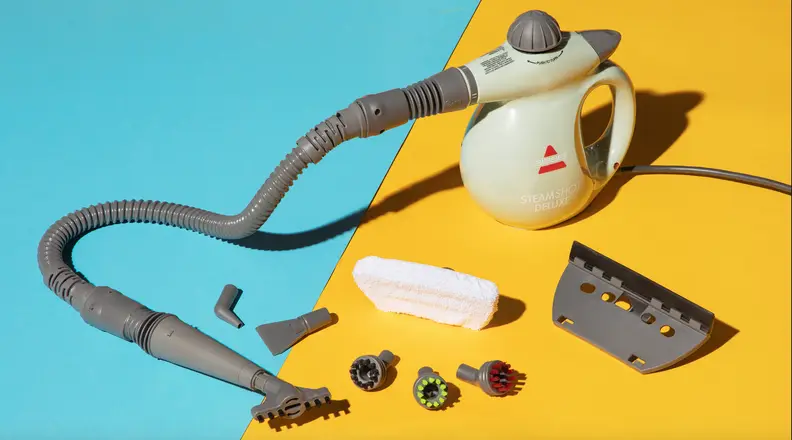 The Bissell Steam Shot Deluxe on a blue and yellow background shown with all of the attachments