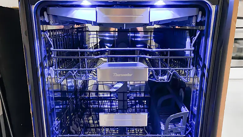 A shot of the interior of the Thermador DWHD770WFM dishwasher, awash in sapphire blue light.