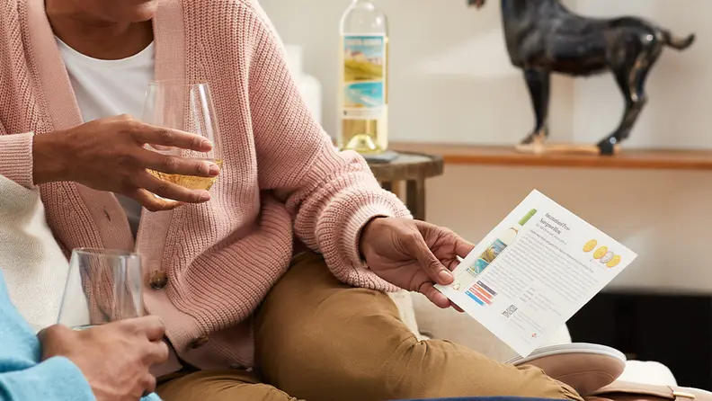 woman holding glass of wine with flavor profile card