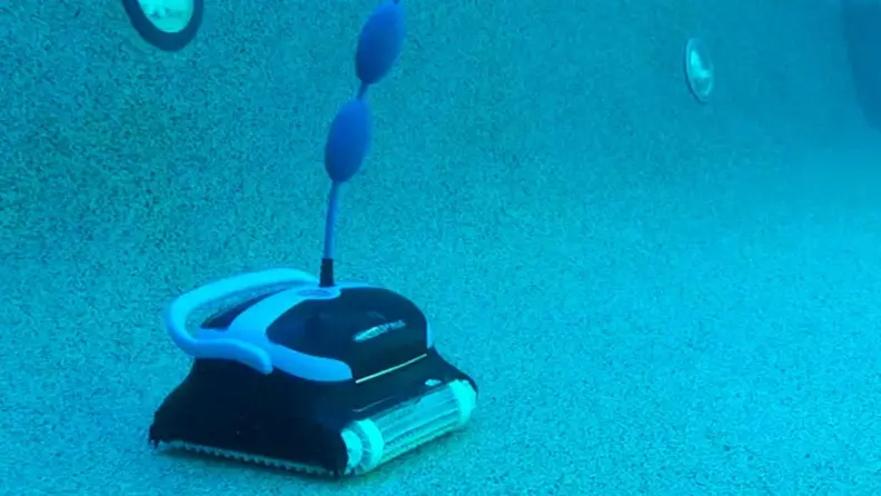 The Dolphin Nautilus CC robotic pool cleaner moving around the bottom of an in-ground swimming pool.