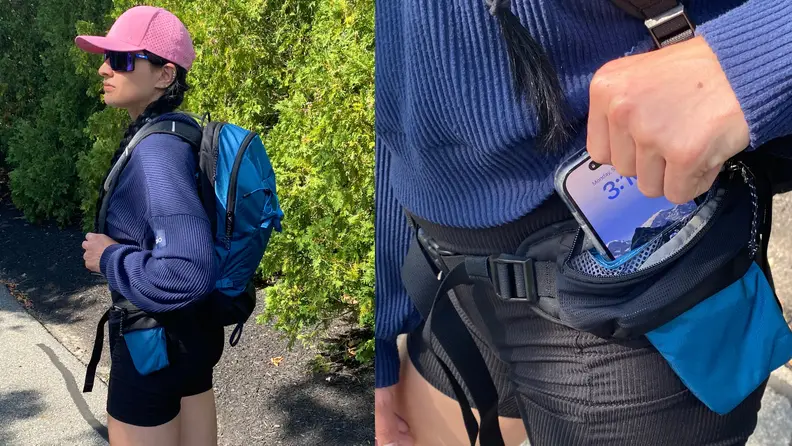 A person stands to the side as they wear the Mammut Lithium 20 Backpack outdoors and a person storing their iPhone in of the pockets..