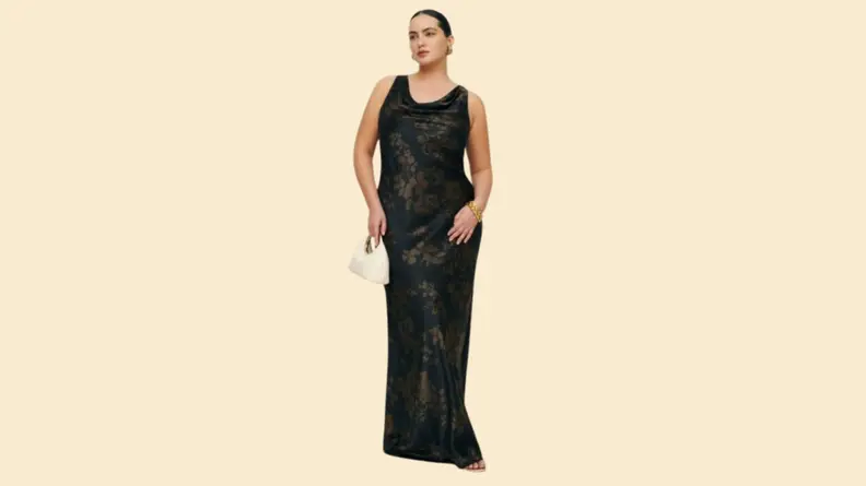 A model wearing a black floor-length gown with a subtle floral print.