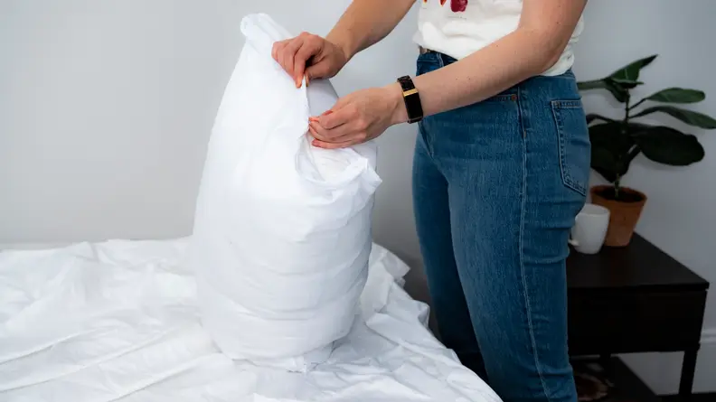 a woman holds a pillow in the target room essentials pillow protector