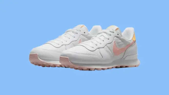 A white pair of Nike shoes on a blue background.